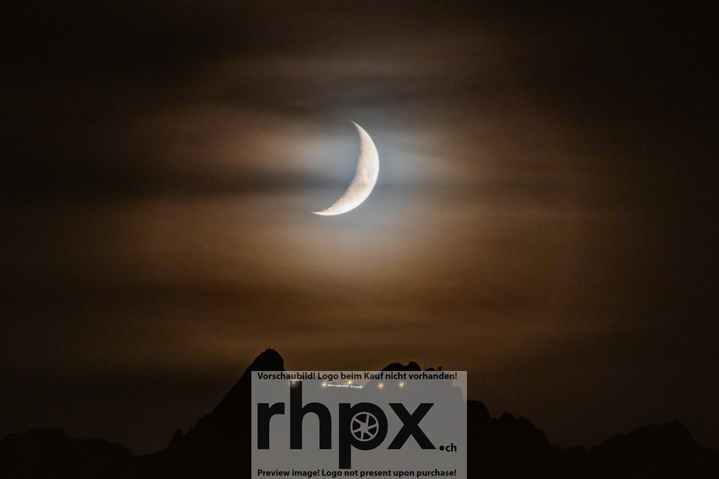 Pilatus Gipfel unter Mondsichel | Nacht. Licht. Geheimnis.Die silbrig leuchtende Mondsichel bricht durch dunne Wolkenschleier und taucht den dunklen Pilatus-Gipfel in eine mystische Aura. Dieses Bild fangt die beeindruckende Stille und Schonheit der Schweizer Alpen unter dem nachtlichen Firmament ein.Wahle unter "Produktauswahl" dein Wunschformat: Vom klassischen Wandbild uber Puzzle &amp; Tassen bis zum digitalen Download (z.B. als Handy-Hintergrund). - Realisiert mit Pictrs.com