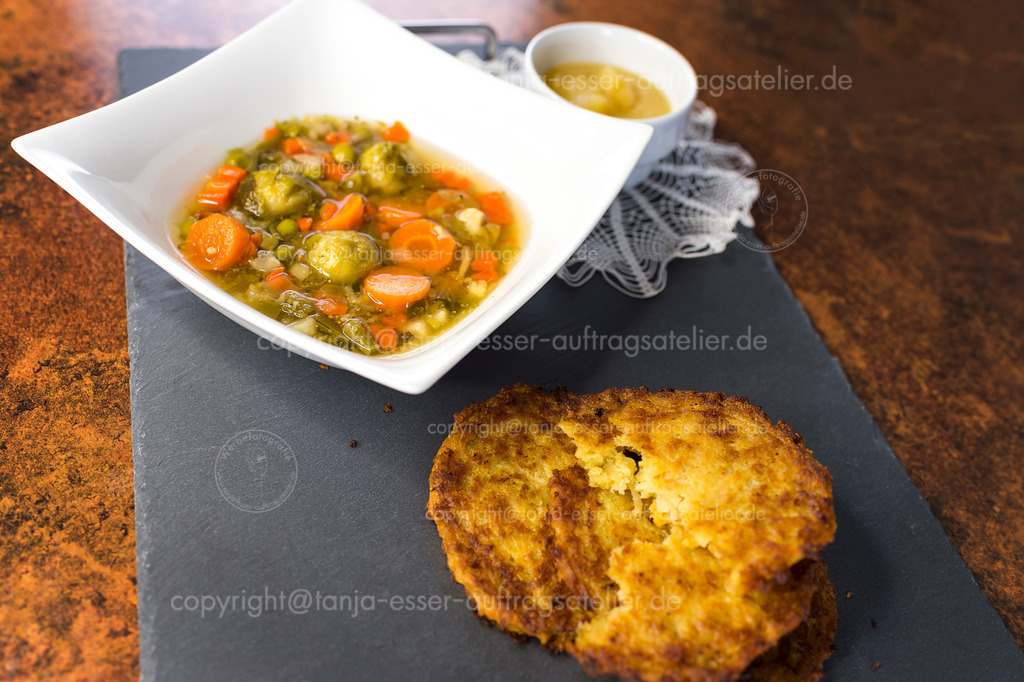 Potatoe fritters with vegetable soup and apple mash | Kartoffelpuffer mit Gemüsesuppe und Apfelmus mit Apfelstückchen auf Schiefertablett.