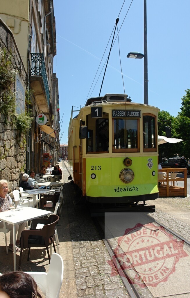 Porto tram traveling along Ribeira street | Vintage yellow tram 213 Passeio Alegre passing outdoor cafe in Porto - Realisiert mit Pictrs.com