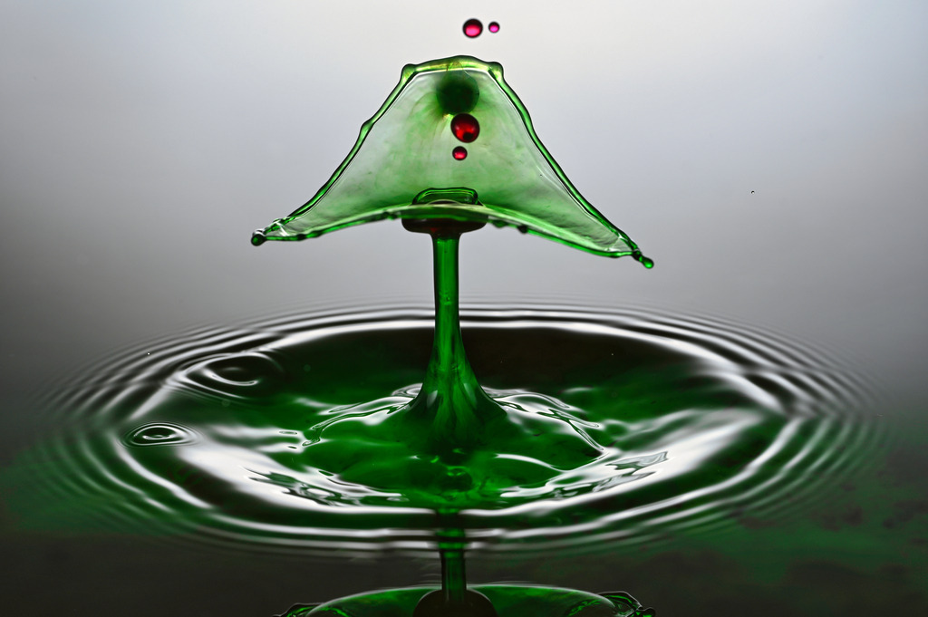 Tannebaum | Dieses faszinierende Foto zeigt eine farbenprächtige Wassertropfen-Kollision in perfektem Moment. Das Ergebnis ist eine Tannenbaumförmiger Tropfen mit roten Weihnachtskugeln. Die feinen Details der Spritzkrone und die sanften Wellen auf der Wasseroberfläche verleihen dem Bild eine künstlerische und fast surreal wirkende Ästhetik. Diese Aufnahme ist ein beeindruckendes Beispiel für Highspeed-Fotografie und die Schönheit flüchtiger Naturmomente.Eine wunderschöne Aufnahme, die gern in orthopädischen Praxen oder beim Physiotherapeuten die Wände ziert. Beruhigend und faszinierend.