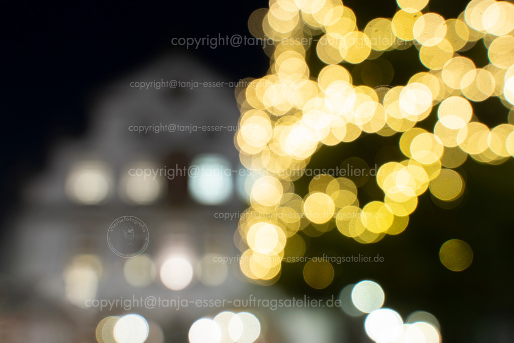 Weihnachtlicher Hintergrund zeigt Briloner Rathaus als unscharfes Bokeh | Rathaus aus Brilon hinter dem großen Weihnachtsbaum auf dem Marktplatz. Schönes Bokeh lässt das Rathaus nur erahnen. Festlicher Hintergrund für Weihnachtsgrüße aus Brilon.