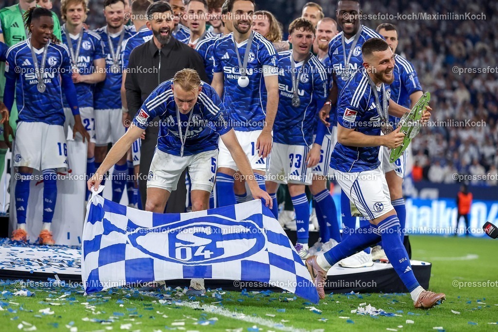 S0417052602054 | 17.05.2026, Fußball, FC Schalke 04 - Eintracht Braunschweig, 34. Spieltag, 2. Fußball Bundesliga, Veltins-Arena Gelsenkirchen, Saison 2025 2026: Schalke 04 ist Meister der 2. Bundesliga. Die Mannschaft gewinnt die Meisterschaft und steht jubelnd auf dem Spielfeld. Freude und Emotionen nach dem Sieg. Timo Becker&nbsp;(Schalke04 #05) und Hasan Kurucay&nbsp;(Schalke04 #04) bei der Siegerehrung mit der Meisterschale und Fahne   DFB regulations prohibit any use of photographs as image sequences and or quasi-video.