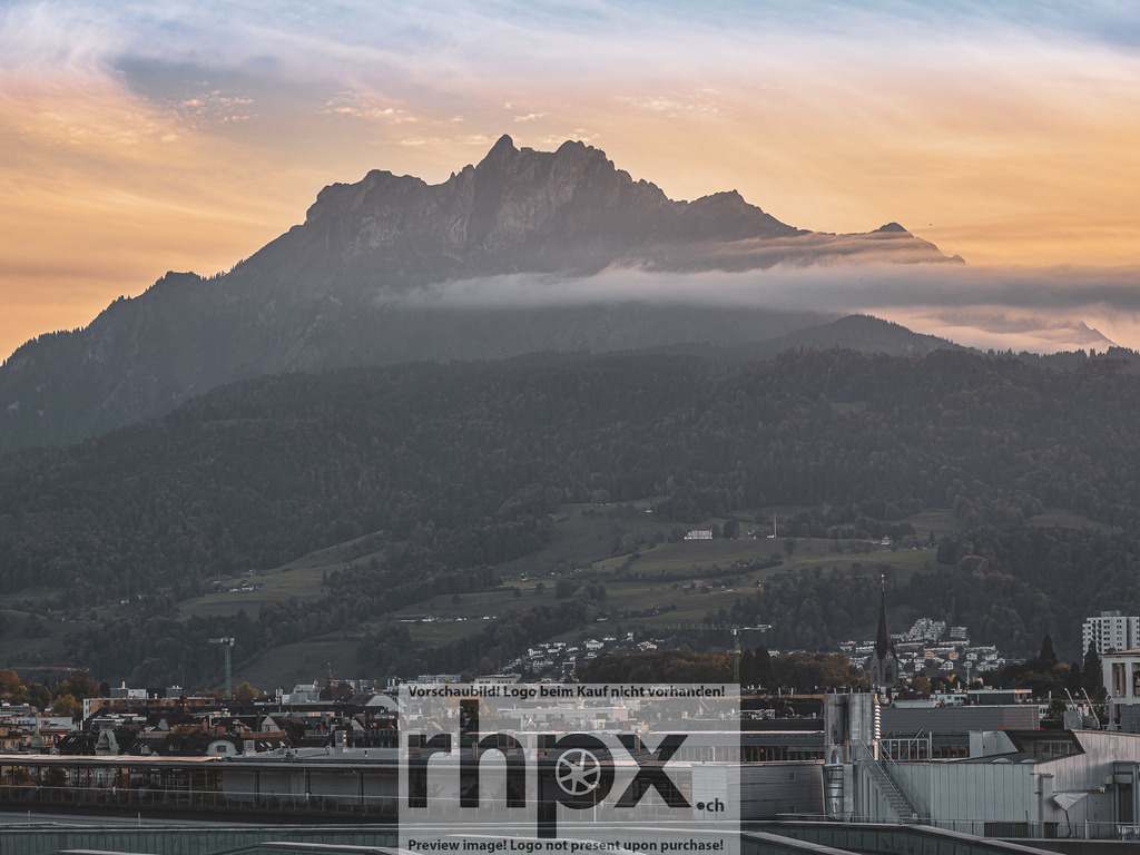 Pilatus im Abendlicht | Fels. Licht. Erhabenheit.Das Pilatusmassiv zeigt sich hier von seiner glanzvollsten Seite, während das warme Abendlicht die schroffen Felsen sanft umspielt. Ein feiner Wolkenschleier verleiht der Szene über den Dächern von Luzern eine beinahe mystische Tiefe. Dieses Motiv bringt die zeitlose Kraft der Schweizer Alpen direkt in deinen Raum.Wähle unter "Produktauswahl" dein Wunschformat: Vom klassischen Wandbild über Puzzle &amp; Tassen bis zum digitalen Download (z.B. als Handy-Hintergrund). - Realisiert mit Pictrs.com