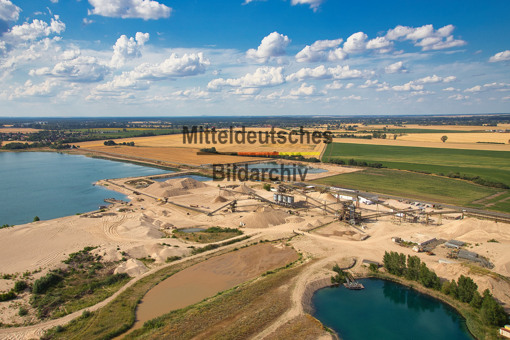 Kieswerk_Hülskens_Barby_1903 | Die Kieswerke der Hülskens Barleben GmbH &amp; Co. KG in Rothensee bei Magdeburg sowie in Tornitz und Barby gehören zu den bedeutenden Standorten der Kies- und Sandgewinnung in Sachsen-Anhalt. Die Luftaufnahmen aus der Perspektive des Tragschraubers zeigen die weitläufigen Abbauflächen mit ihren großen Kiesseen, modernen Förder- und Aufbereitungsanlagen sowie der leistungsfähigen Betriebstechnik. Aus der Vogelperspektive werden die Dimensionen der Rohstoffgewinnung und die enge Verbindung von Gewinnung, Aufbereitung und Rekultivierung eindrucksvoll sichtbar. - Realisiert mit Pictrs.com