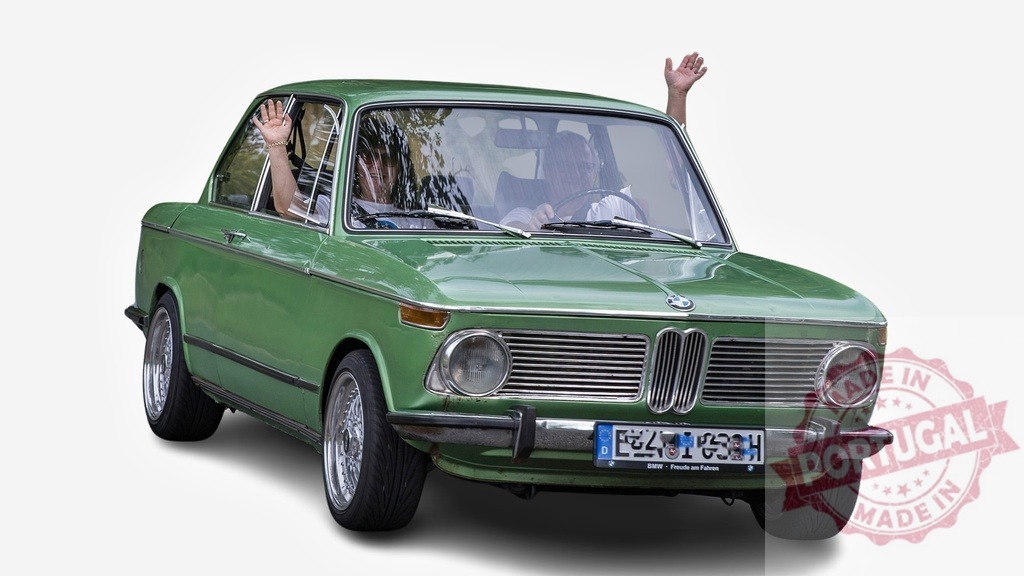 Happy tourists waving from vintage green BMW car | Senior couple waving from vintage green BMW during a summer road trip - Realisiert mit Pictrs.com