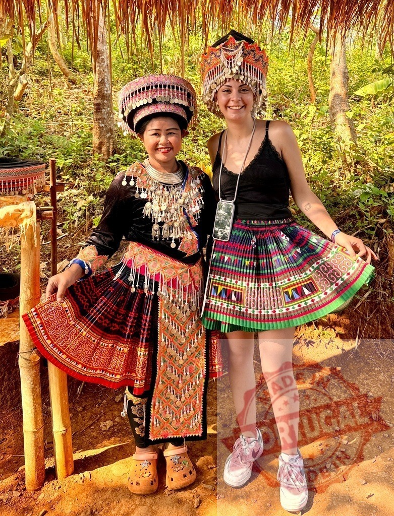 Hmong woman and tourist trying traditional clothing in Thailand | Ethnic Hmong woman and female tourist posing in traditional clothes and ornate silver jewelry - Realized with Pictrs.com