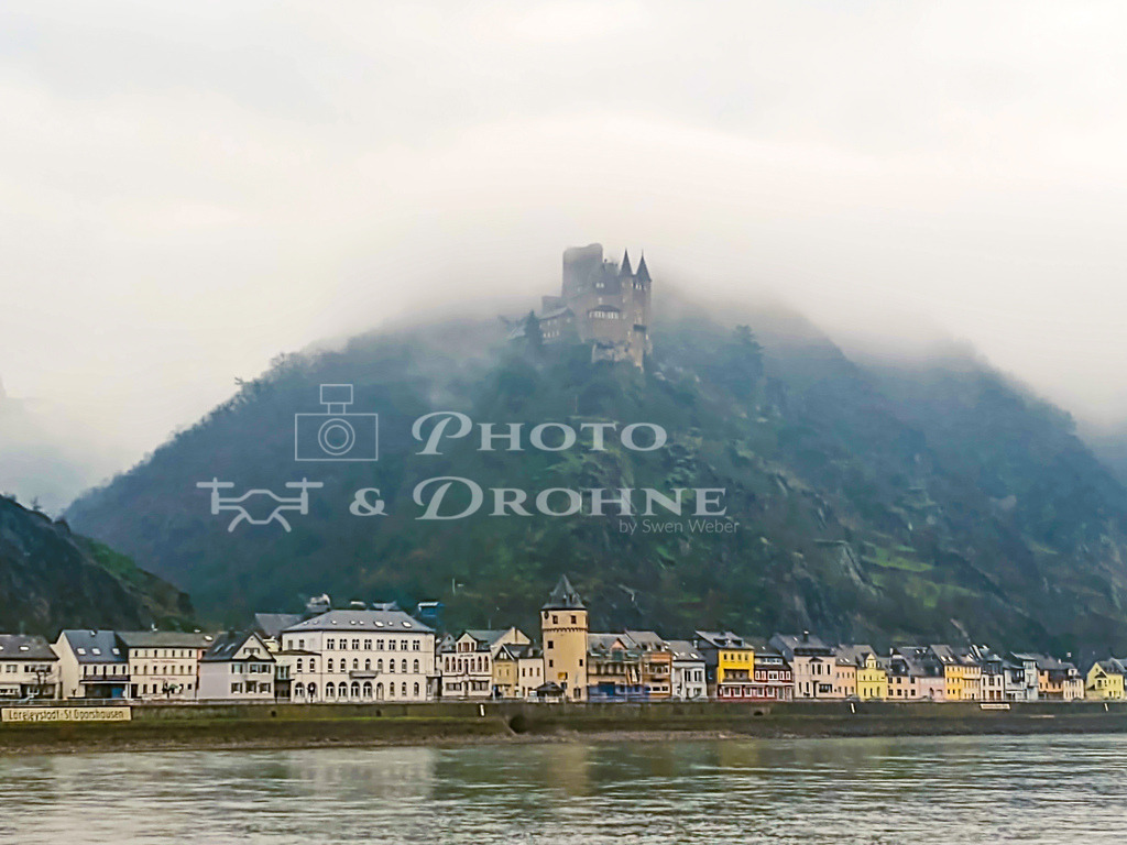 Burg Katz-091445125 | Blick von Sankt Goar nach Sankt Goarshausen mit der Burg Katz im Frühnebel. Im Frühjahr und im Herbst kann man hier die tollsten Nebelbilder fotografieren. Gerne zeigen wir es Ihnen auf einer unserer Fototouren am Oberen Mittelrhein. - Realisiert mit Pictrs.com