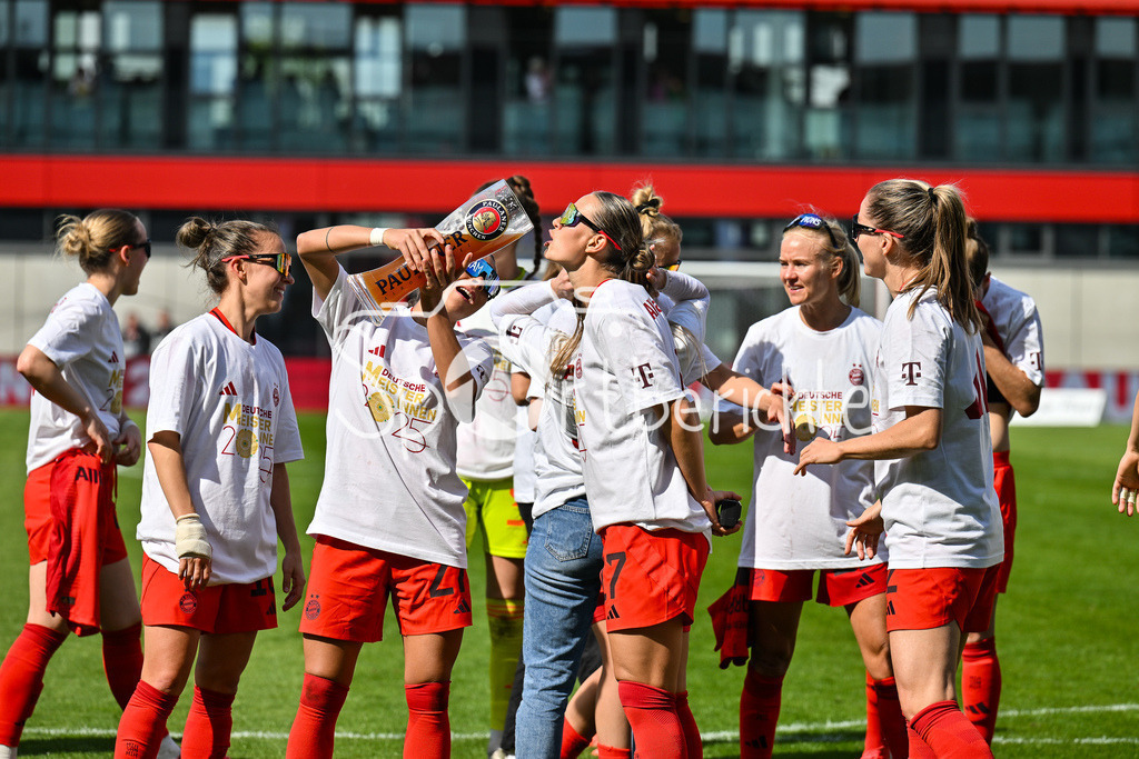 FC Bayern München - SC Freiburg | Die Spielerinnen des FC Bayern feiern die Meisterschaft nach dem Heimsieg gegen den SC Freiburg / Frauen Bundesliga: FC Bayern Muenchen - SC Freiburg, FC Bayern Campus am 27.04.2025 / Arianna CARUSO (FC Bayern Muenchen Frauen 27) gibt Klara BUEHL (FCB #17) einen Schluck auf dem Paulaner Bierkrug / Bierglas