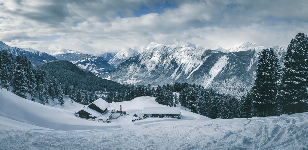 Winterpanorama – Feldringalm in Tirol | Verschneite Hütten, tief verschneite Bäume und ein imposanter Blick auf die Tiroler Alpen: Dieses Panorama von der Feldringalm zeigt die klare, ruhige Schönheit des Winters in den Bergen – perfekt für alle, die Weite lieben. - Realisiert mit Pictrs.com