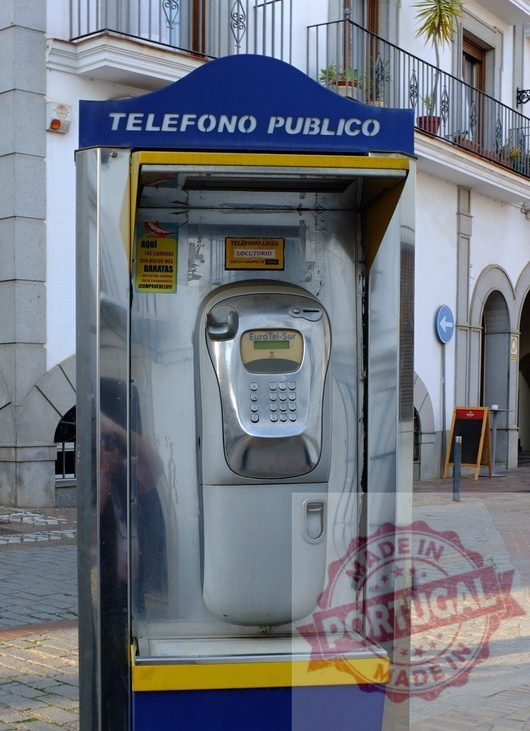 Public telephone booth standing on a street in Spain | Public pay phone booth with Euro Tel Sur sign standing on a paved street in Spain - Realized with Pictrs.com