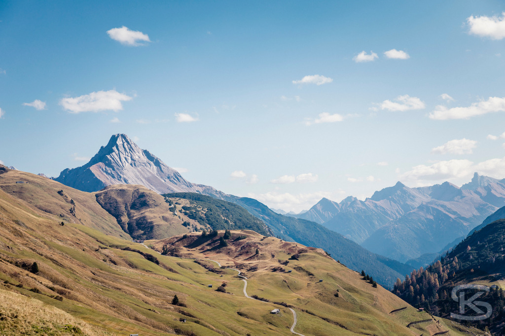 Blick auf den Biberkopf - Alpenpanorama Allgäuer Alpen | Malerisches Bergpanorama mit Blick auf den markanten Biberkopf in den Allgäuer Alpen. Sanfte Almwiesen im Vordergrund, der charakteristische Gipfel und weitere Alpenketten unter strahlend blauem Himmel vereinen sich zu einem klassischen Alpenmotiv. - Realisiert mit Pictrs.com