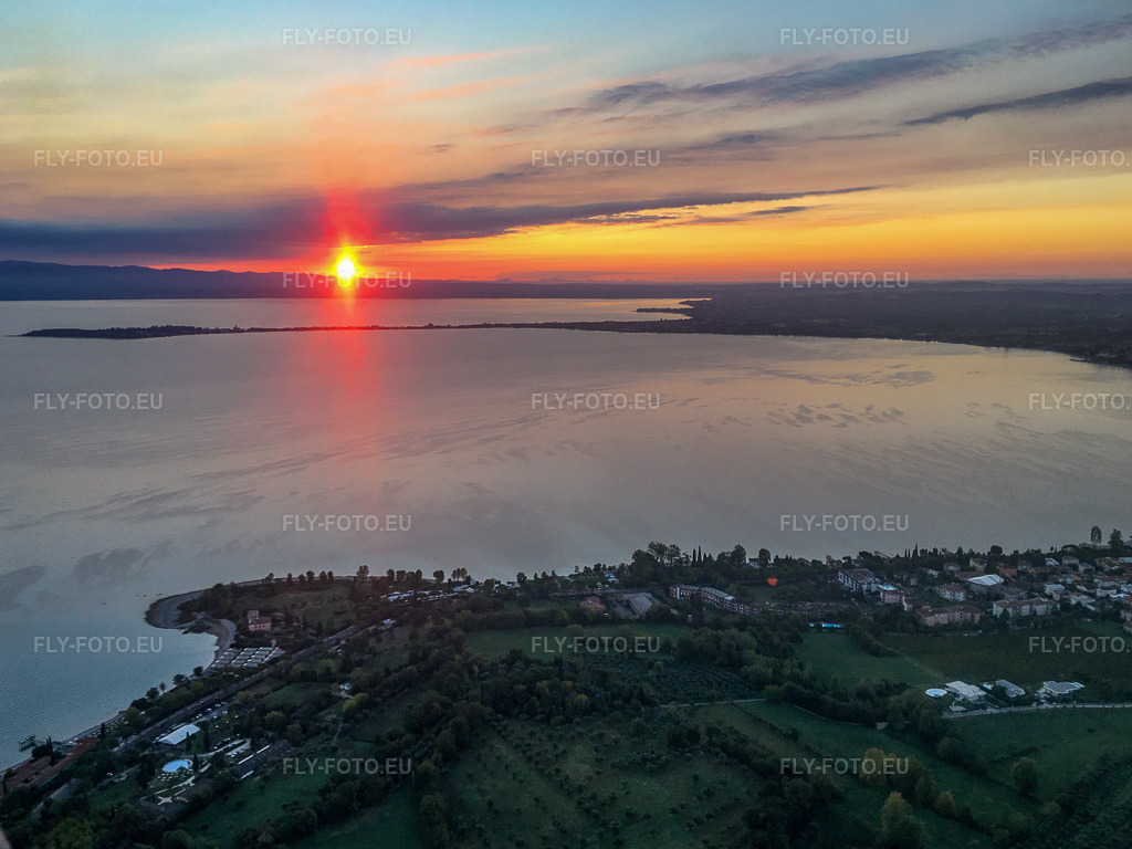 Vue aérienne: Lever du soleil au Campeggio del Vò Lac de Garde à Desenzano del Garda dans le département Brescia, Italie. Photo: IMG-134974.jpg prise le 23/09/2022 par Werner Riehm/FLY-FOTO.eu – Résolution de l'original: 3839 x 2879 px