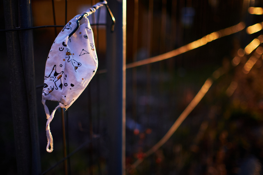 aufgehängte verlorene Kindermaske im Morgenlicht | Wien, Austria - March 13, 2021: Massnahmen zur Einschränkung von COVID-19; aufgehängte verlorene Kinder Mund- und Nasenschutzmaske im Morgenlicht. - Realisiert mit Pictrs.com