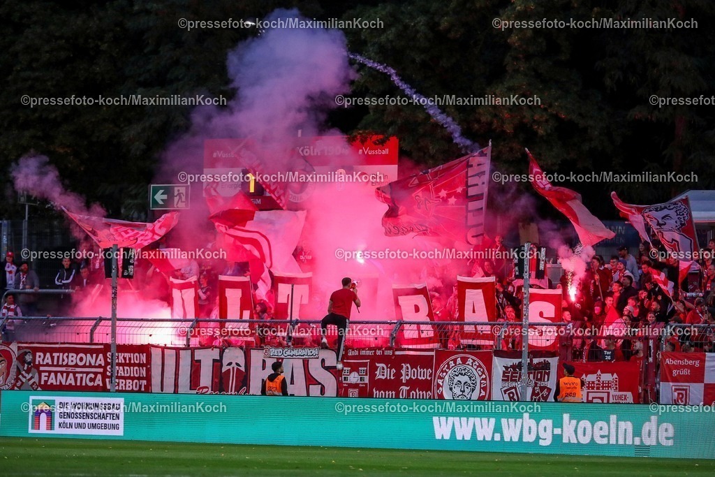 FCVK29082501077 | 29.08.2025, Fußball, FC Viktoria Köln – SSV Jahn Regensburg, 3.Liga, Sportpark Höhenberg, Saison 2025 2026: Die Fans von Jahn Regensburg zünden in der zweiten Halbzeit bengalisches Feuer auf der Gästetribüne. Pyrotechnik brennt im Gästeblock. Choreo Choreografie Choreography Feuerwerkskörper Bengalos.  DFB regulations prohibit any use of photographs as image sequences and or quasi-video.