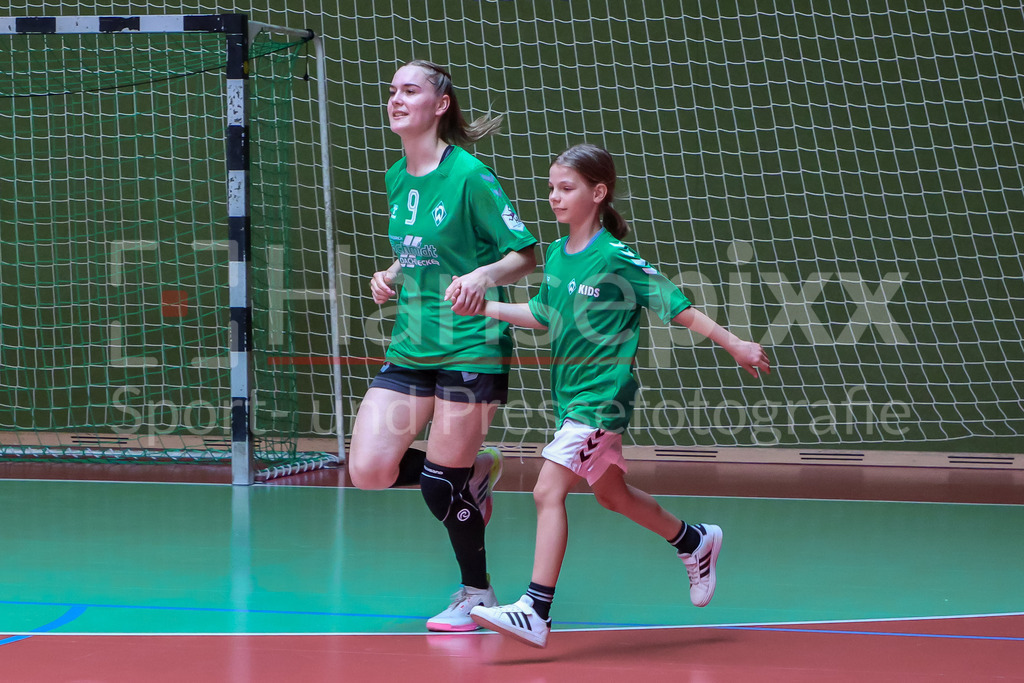 Handball, 2. Bundesliga Frauen, SV Werder Bremen - SV Union Halle-Neustadt | Luca Schumacher (SV Werder Bremen, 9) beim Einlaufen mit Begleitung durch ein Kind des Werder Kids Clubs