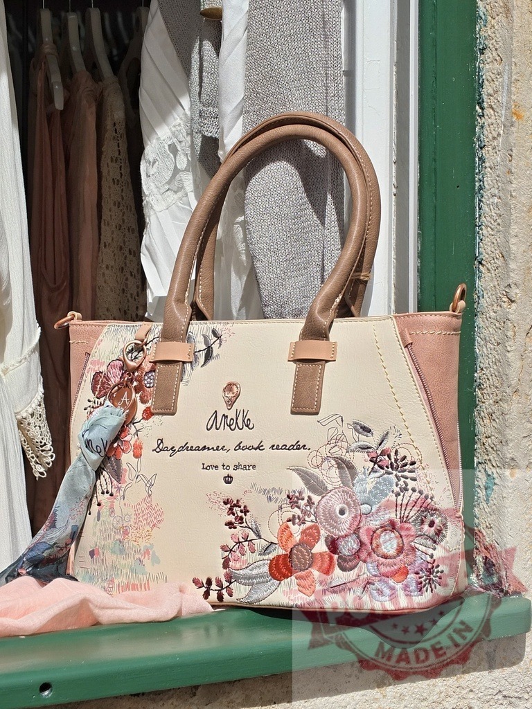 Anekke handbag with floral embroidery on window ledge | Anekke brand handbag featuring intricate floral embroidery and inspirational text on a window ledge - Realized with Pictrs.com