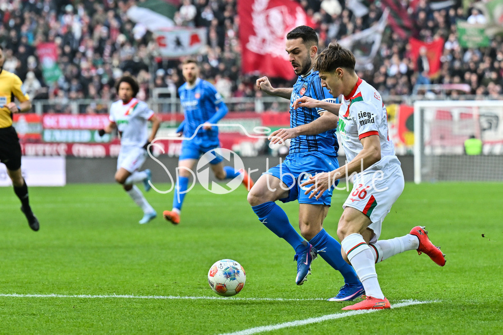 FC Augsburg - 1. FC Heidenheim | AUGSBURG, GERMANY - 15. FEBRUARY: im DUell Arijon IBRAHIMOVIC (1. FC Heidenheim 22) und Mert KOEMUER (KÖMÜR, KOMUR, FC Augsburg 36) während dem Bundesligamatch zwischen dem FC Augsburg und dem 1. FC Heidenheim am 22. Spieltag in der WWK-Arena / DFL REGULATIONS PROHIBIT ANY USE OF PHOTOGRAPHS AS IMAGE SEQUENCES AND/OR QUASI-VIDEO