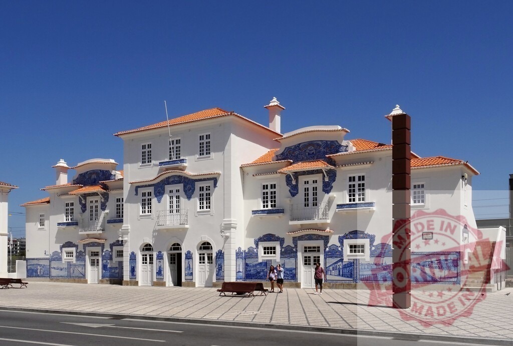 Aveiro Railway Station facade with azulejo tiles in Portugal | Aveiro Railway Station featuring traditional Portuguese azulejo tile panels under a clear blue sky - Realized with Pictrs.com