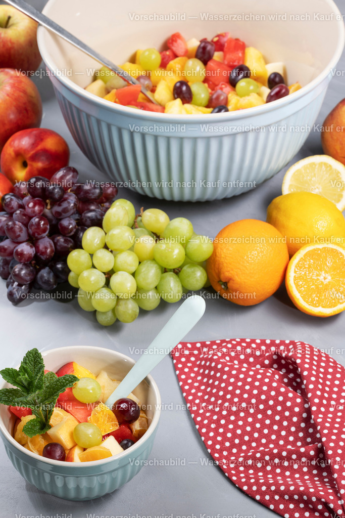frisch zubereuteter Obstsalat in einer großen Schüssel und dazu passender gefüllter Dessertschale | frisch zubereuteter Obstsalat in einer großen Schüssel und dazu passender gefüllter Dessertschale. Mit Obst und Minze dekoriert. - Realisiert mit Pictrs.com