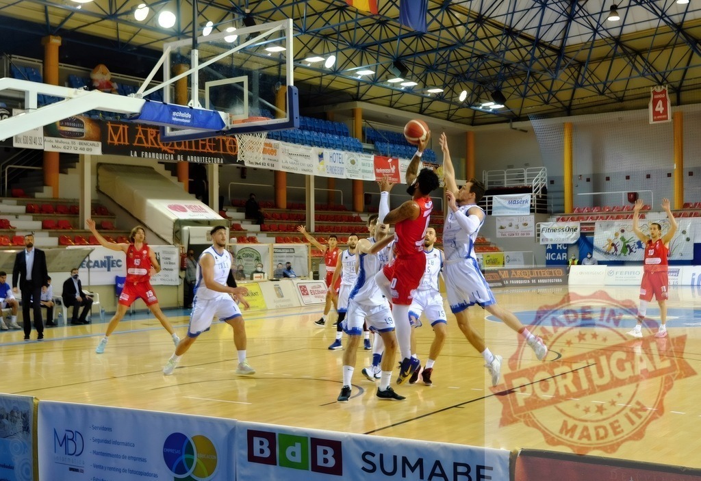 Basketball players competing during an indoor game | Basketball players from opposing teams jumping for the ball during an intense competition - Realized with Pictrs.com
