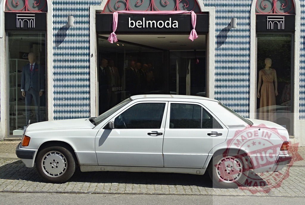 White Mercedes-Benz 190E parking outside Belmoda fashion boutique | White classic Mercedes-Benz 190E car parked on a street outside a closed fashion boutique - Realized with Pictrs.com