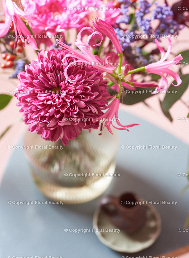 Draufsicht rosa Dahlien und Chrysanthemen auf grauem Tischchen | Dahlien und Chrysanthemen in Glasvase von oben auf einem grauen Tischchen - schön als Postkarte - Realized with Pictrs.com