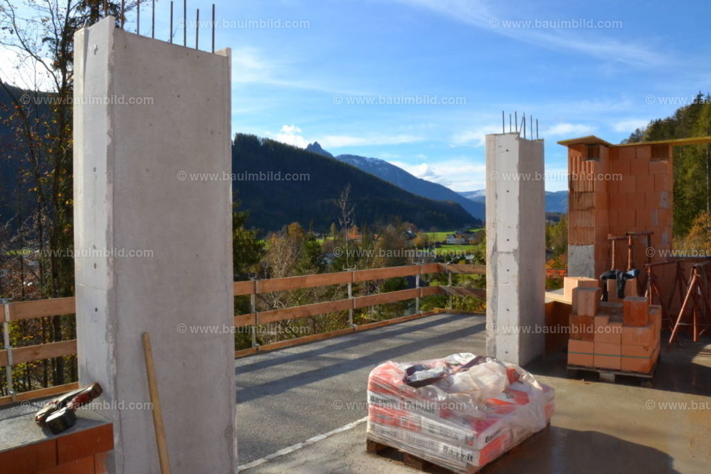 Balkonplatte und Betonsäulen | Balkonplatte in Ortbeton mit Schutzgeländer, Betonstützen und Ziegelmauerwerk, Hintergrund blauer Himmel
