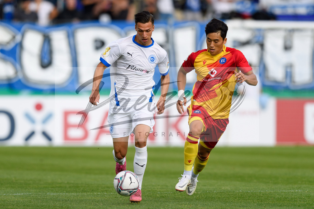 LOTKSC20210809_075 | Fussball, Herren: Tyson Richter (Sportfreunde Lotte) und Kyoung-rok Choi (Karlsruher SC) im Zweikampf beim Spiel der 1. Runde im DFB-Pokal zwischen SF Lotte und Karlsruher SC im Stadion am Lotter Kreuz am 09.08.2021 in Lotte, Deutschland.DFB / DFL REGULATIONS PROHIBIT ANY USE OF PHOTOGRAPHS AS IMAGE SEQUENCES AND/OR QUASI-VIDEO. - Realisiert mit Pictrs.com