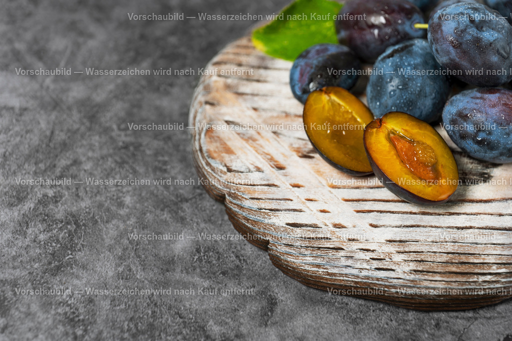 frisch geerntete, saftige Pflaumen auf rustikalen Holzbrett | frisch geerntete, saftige Pflaumen auf rustikalen Holzbrett, eine Pflaume ist aufgeschnitten - Realisiert mit Pictrs.com