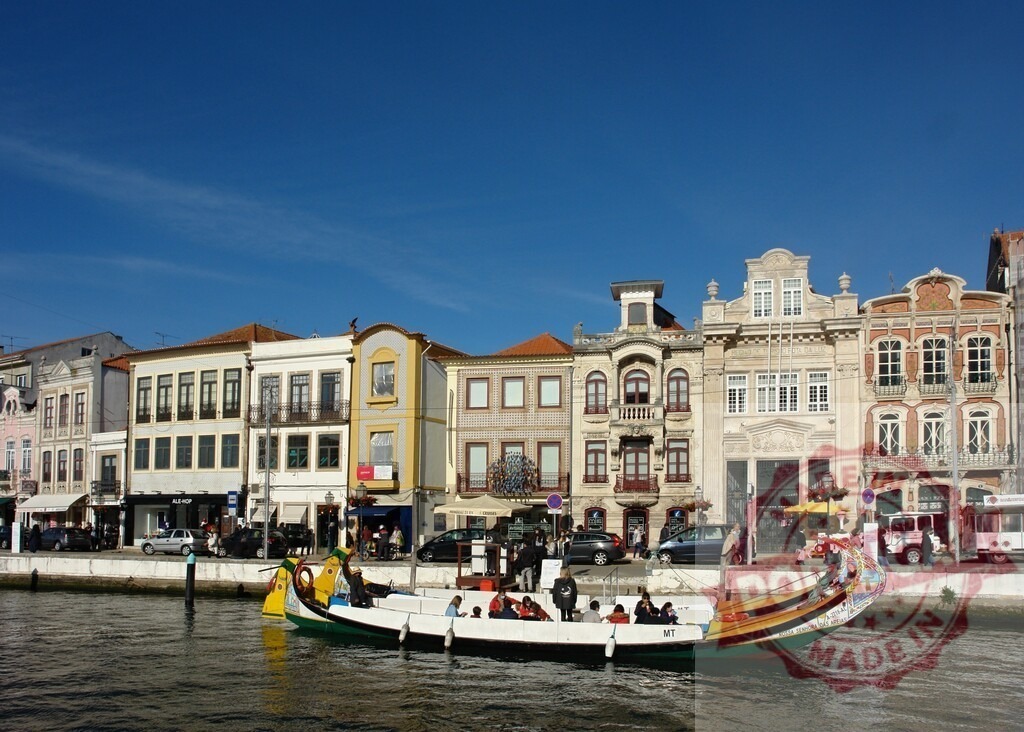 Moliceiro boat transporting tourists on Aveiro canal | Moliceiro boat carrying tourists along the canal in Aveiro, Portugal, with historic buildings - Realized with Pictrs.com