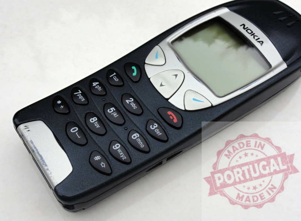 Nokia 3310 mobile phone showing keypad and screen | Old Nokia 3310 cell phone lying on a white surface - Realized with Pictrs.com