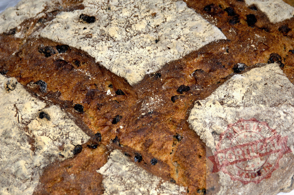 Rustic homemade raisin bread loaf close-up texture | Raisin bread loaf showing characteristic cross-cut and rustic, flour-dusted crust - Realized with Pictrs.com