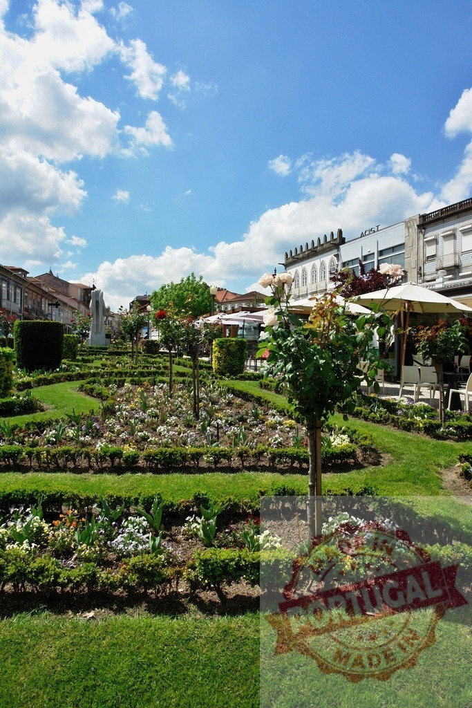 República garden in Tui, Galicia, Spain during daytime. Region Norte - Portugal | Green manicured garden with blooming flowers and decorative hedges in a town square - Realized with Pictrs.com