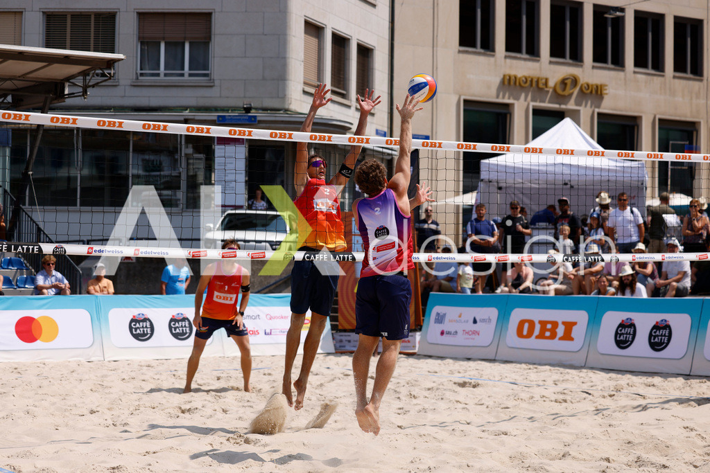 Obi BeachTour 2026 - Basel | BASEL, SWITZERLAND - JULY 19: YVES HAUSSENER (SUI) attack / spike against LUC EMANUEL FLÜCKIGER (SUI) block during the Obi BeachTour 2026 match between DILLIER / FLÜCKIGER (SUI) and HAGENBUCH / HAUSSENER (SUI) at Barfüsserplatz on July 19, 2026 in Basel, Switzerland. - Realisiert mit Pictrs.com