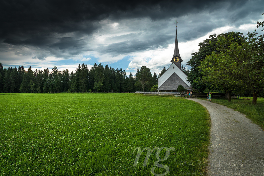Gewitterstimmung über der Kirche Wützbrunnen in Röthenbach im Emmental | Die ideale Geschenkidee für Naturliebhaber. Naturbilder von Marcel Gross Photography für ihr Zuhause in den verschiedensten Formaten und Materialien. - Realisiert mit Pictrs.com