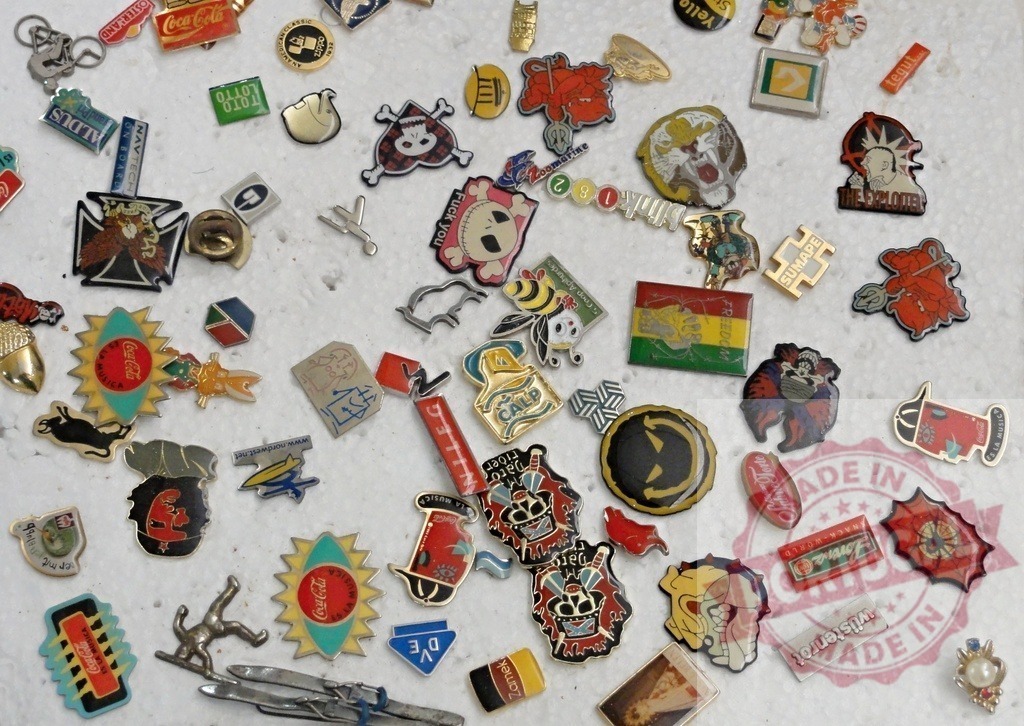 Collection of assorted vintage enamel lapel pins | Variety of colorful decorative metal pins scattered forming a background - Realized with Pictrs.com