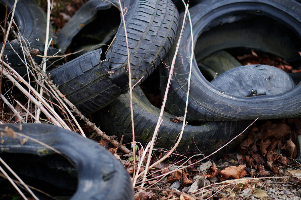 Alte Autoreifen in der Landschaft liegend | Wien, Austria - April 15, 2021: Alte Autoreifen in der Landschaft liegend. - Realisiert mit Pictrs.com