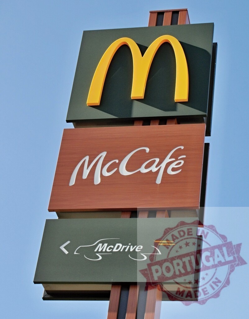 McDonald's fast food restaurant sign with golden arches | McDonald's outdoor sign displaying branding for McCafé and McDrive services - Realized with Pictrs.com