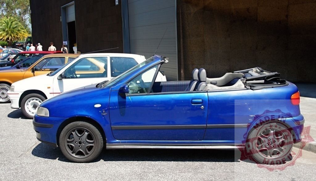 Blue Fiat Punto Cabrio Sporting parked near other cars | Side view of a blue Fiat Punto Cabrio Sporting parked near other cars in a parking lot - Realized with Pictrs.com