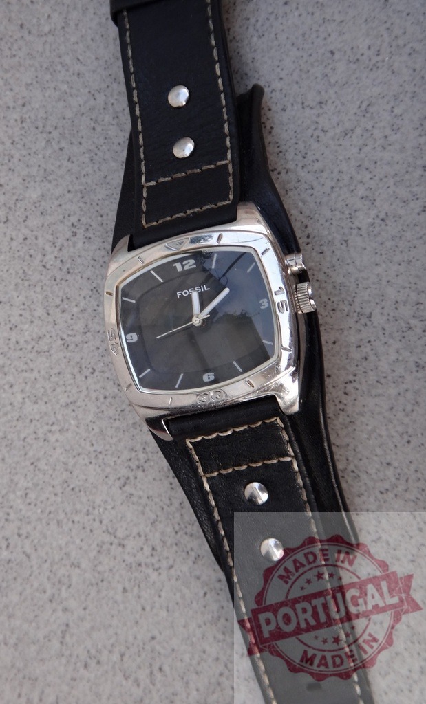Fossil watch with black leather cuff strap and silver studs | Fossil watch with black dial and leather cuff strap on a gray background - Realized with Pictrs.com
