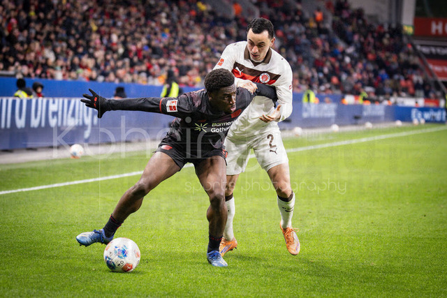 Bayer 04 Leverkusen vs. FC St. Pauli, 14.02.2026 | LEVERKUSEN, GERMANY - FEBRUARY 14:  Ernest Poku (Bayer 04 Leverkusen, 19) and Manolis Saliakas (FC St. Pauli, 2) tackling during the Bundesliga match (gameday 22)  between Bayer 04 Leverkusen vs. FC St. Pauli at BayArena on February 14, 2026 in Leverkusen, Germany. (Photo by Axel Kohring/Beautiful Sports Int.)DFL REGULATIONS PROHIBIT ANY USE OF PHOTOGRAPHS AS IMAGE SEQUENCES AND/OR QUASI-VIDEO.