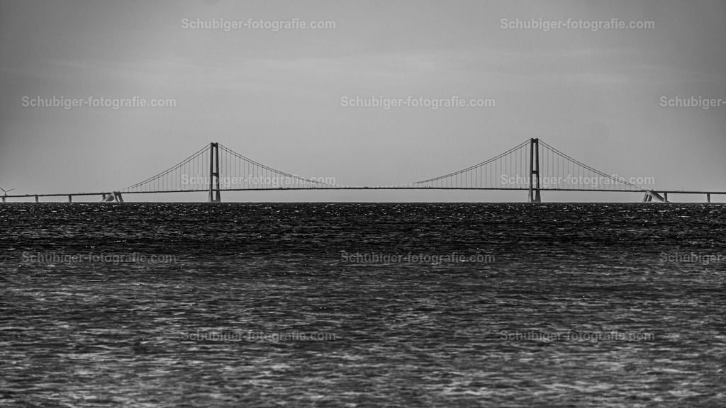 Storebæltbrücke | Storebæltsforbindelsen ist die rund 18 km lange feste Verkehrsverbindung über den Großen Belt zwischen Slagelse auf der dänischen Insel Seeland und Nyborg auf Fünen. Über sie verlaufen die Eisenbahnverbindung København–Fredericia und die Europastraße 20. Wikipedia - Realisiert mit Pictrs.com