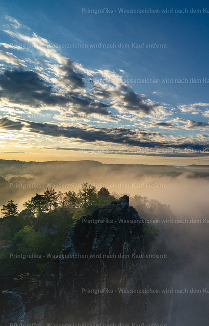 Felsen im Morgennebel | Hochformatige Landschaftsaufnahme einer nebligen Felsformation im frühen Morgenlicht. Der weite Himmel, die dunklen Felsen und der sanfte Nebel schaffen eine ruhige, eindrucksvolle Naturstimmung. - Realisiert mit Pictrs.com