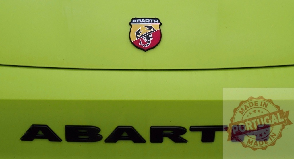 Abarth scorpion logo and brand name on lime green car | Abarth scorpion emblem and black letters on a vibrant green car, showing Italian automotive branding - Realized with Pictrs.com