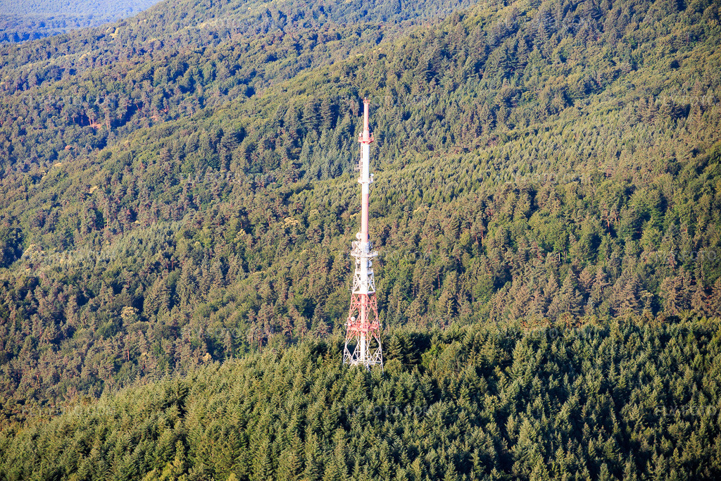 Aerial view: Red and white transmission tower at the Col du Pigeonnier in Wissembourg in the state Bas-Rhin, France. – Photo: IMG_157816.jpg taken on 06/19/2026 by Werner Riehm/FLY-FOTO.com – Resolution of the original: 6000 x 4000 px