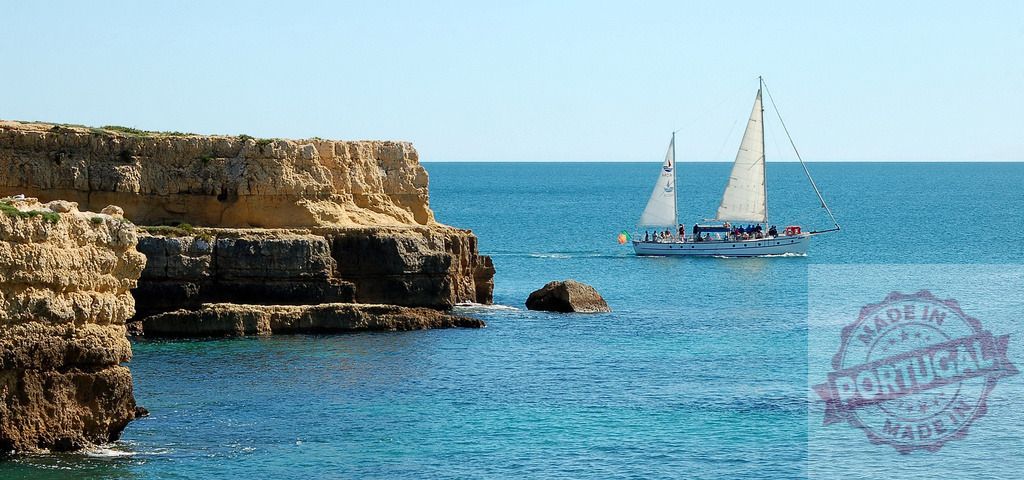 Sailboat cruising along the sunny Algarve coast | Sailboat carrying people sailing near rugged cliffs in the clear blue sea - Realisiert mit Pictrs.com