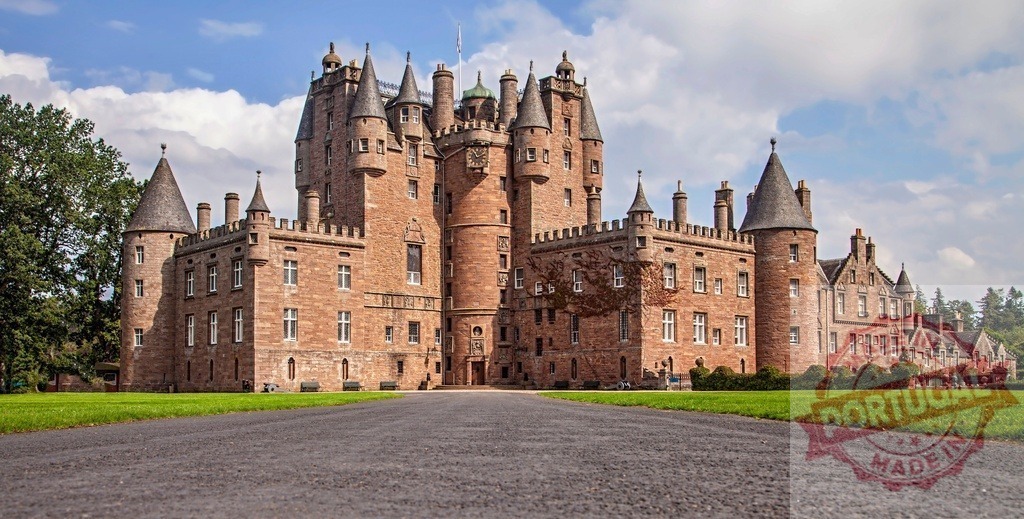 Glamis Castle historic Scottish landmark building | Glamis Castle standing amidst green lawns under blue sky with clouds - Realized with Pictrs.com