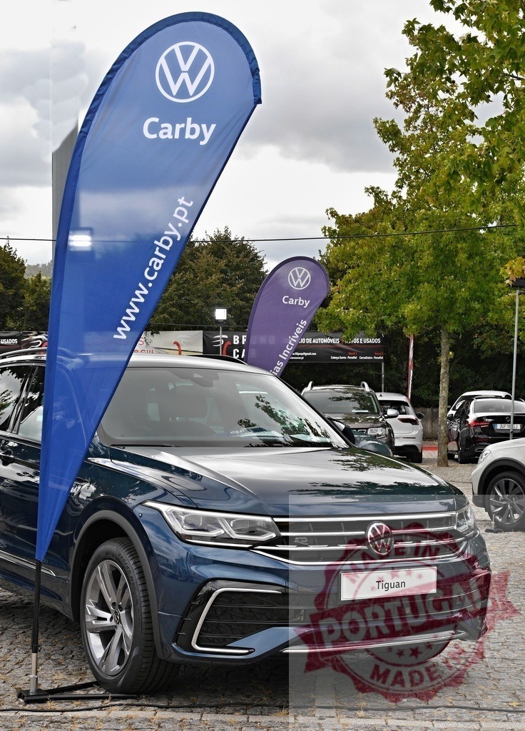 Volkswagen Tiguan SUV displayed at Carby dealership outdoor event | Volkswagen Tiguan SUV parked outdoors with Carby dealership feather flags - Realisiert mit Pictrs.com