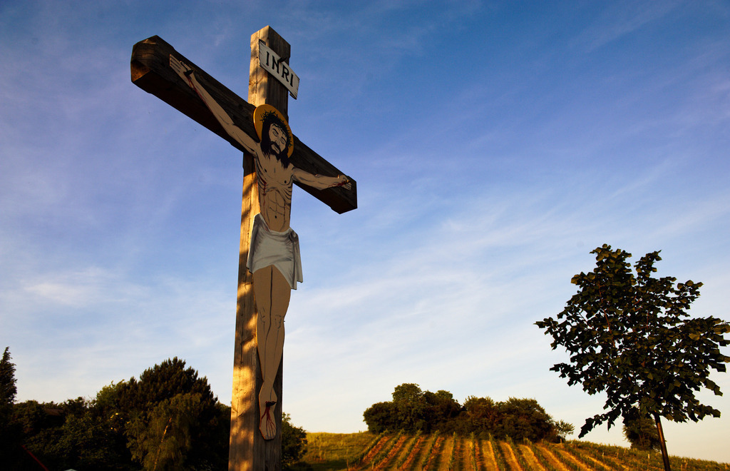 Kreuz vor Weinberg | Enzersfeld, Austria - May 29, 2012: Kreuz mit Jesus steht vor einem Weinberg, bei blauem Himmel. - Realisiert mit Pictrs.com