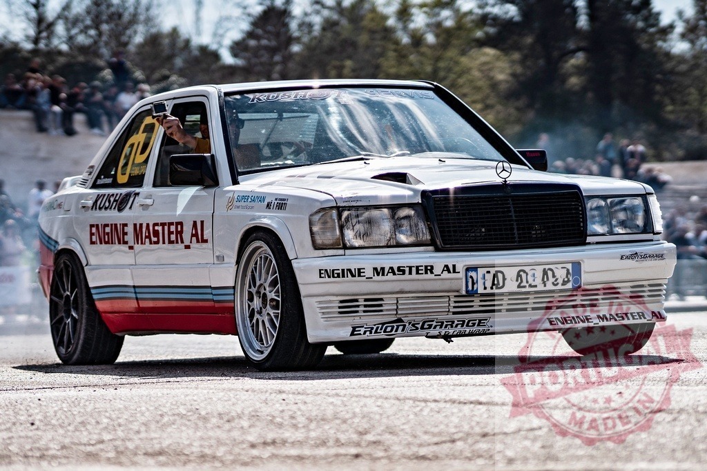Mercedes-Benz 190E race car drifting on track | Sports car performing a drift, generating smoke from tires on asphalt - Realisiert mit Pictrs.com